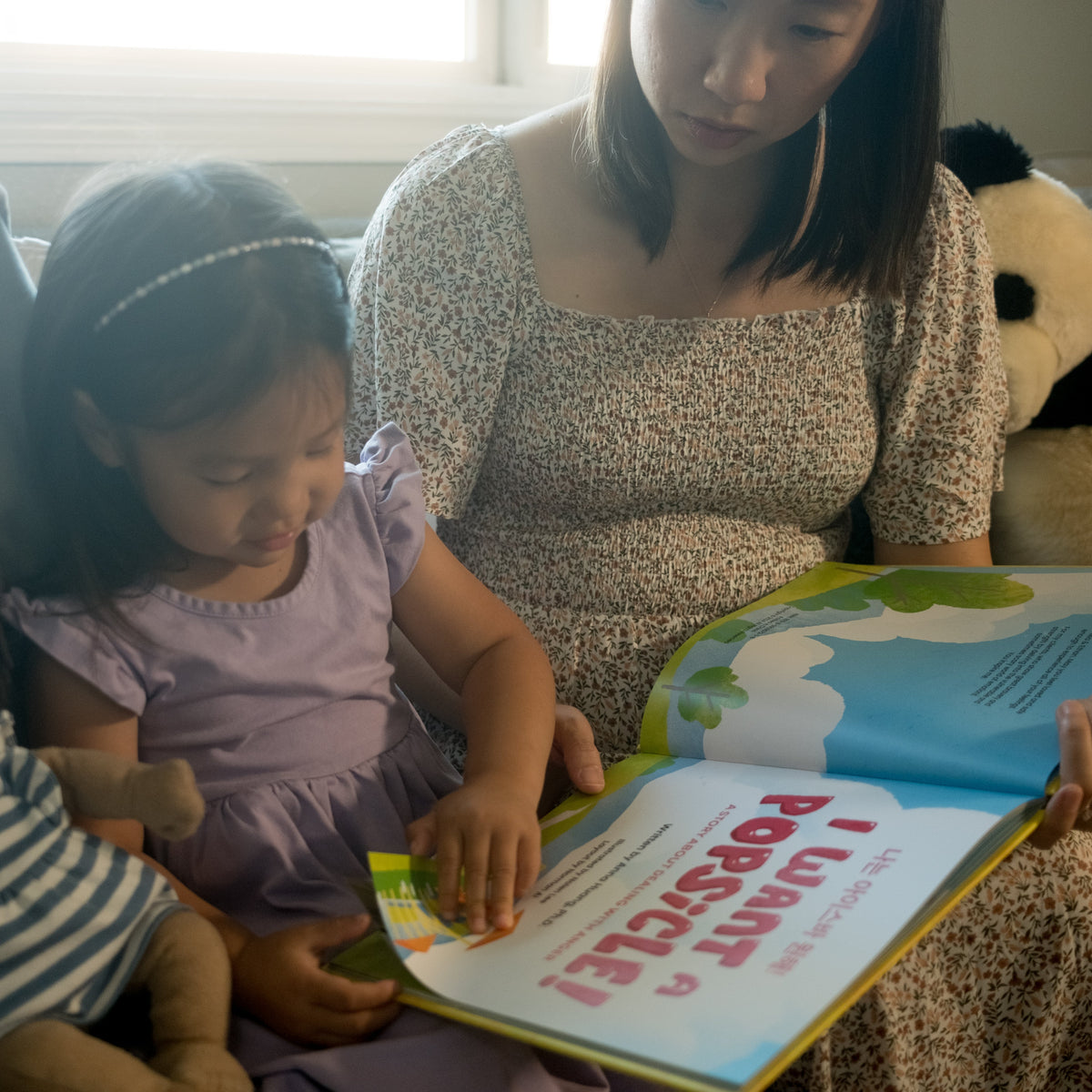 A parent and child reading a picture book together