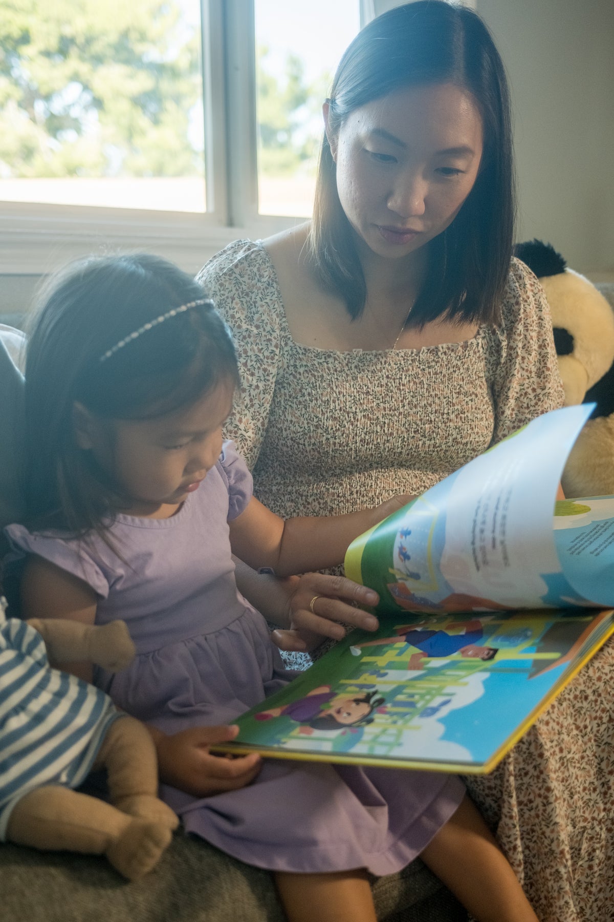 A mom and daughter turning the pages of a Mindful Peach book